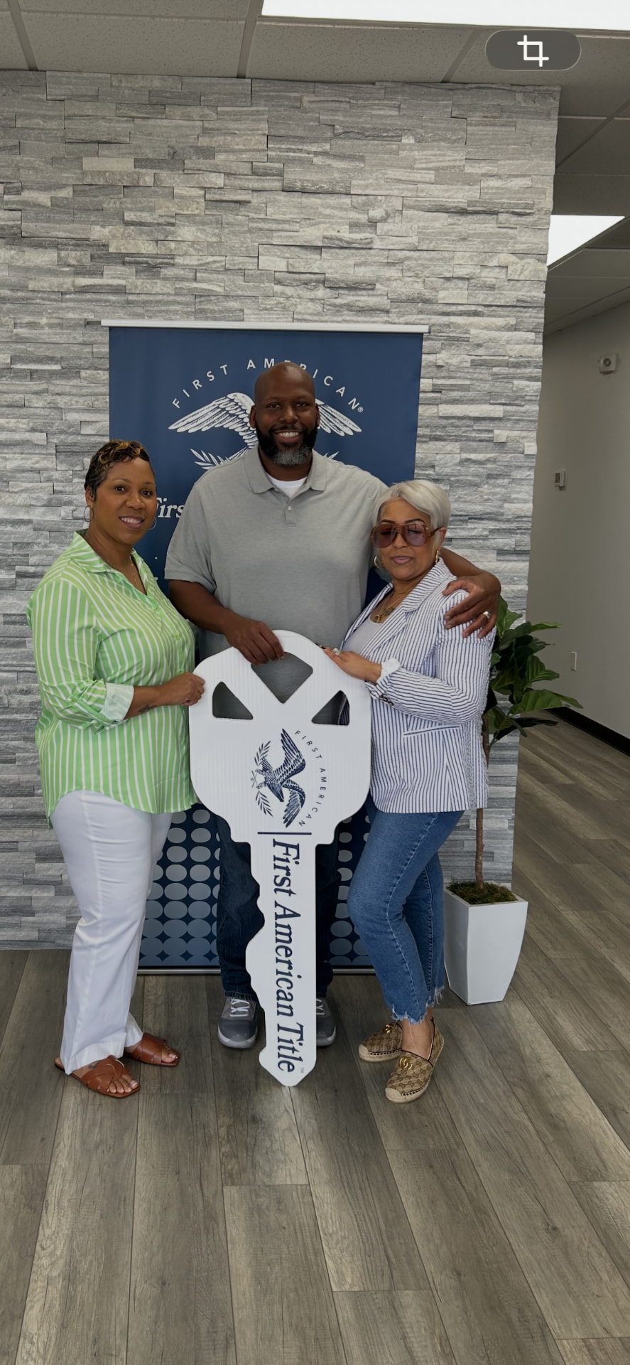 Karaunda Frederick with her clients on closing day, holding the keys sign