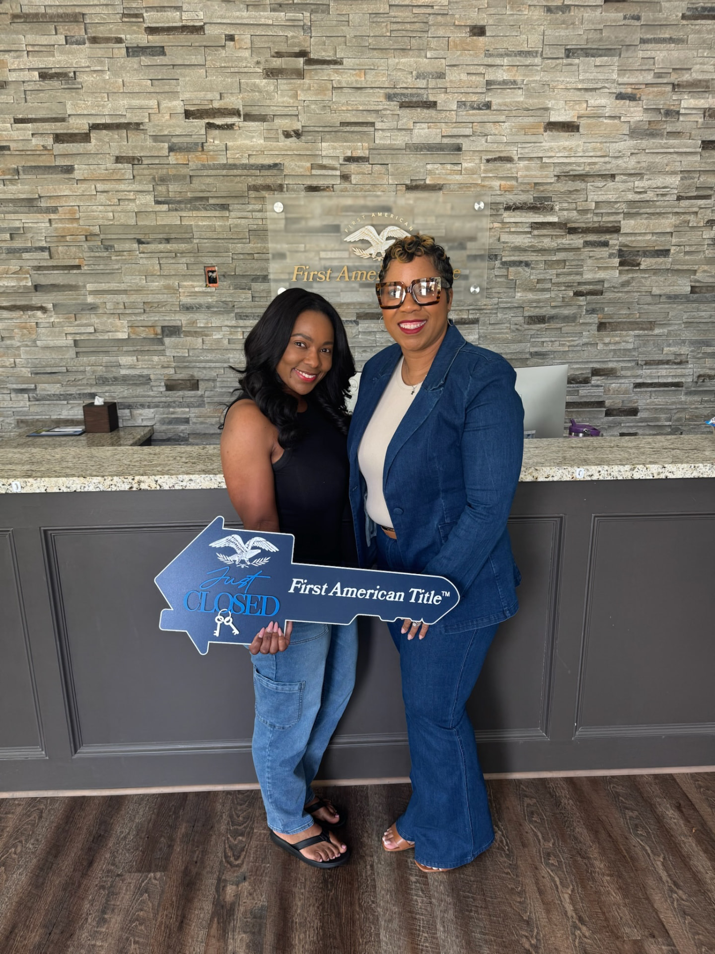 Karaunda Frederick celebrating with a client holding a Just Closed key at the title office